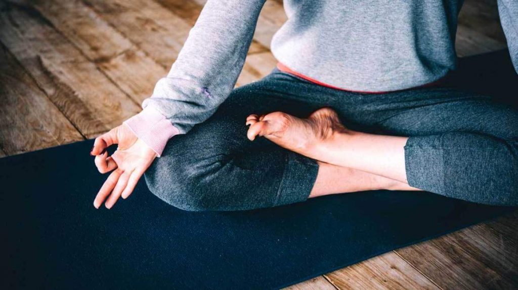 Legs crossed on yoga mat