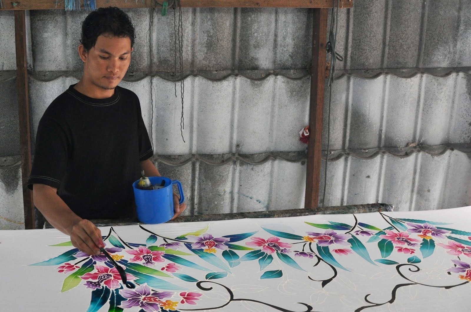 Malaysian making local batik on a piece of cloth