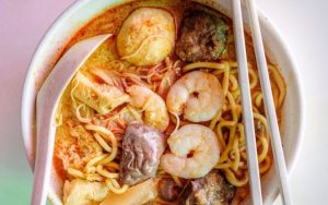 A bowl of Penang curry mee with chopsticks