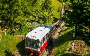 a red and white colour funicular train going up the hill