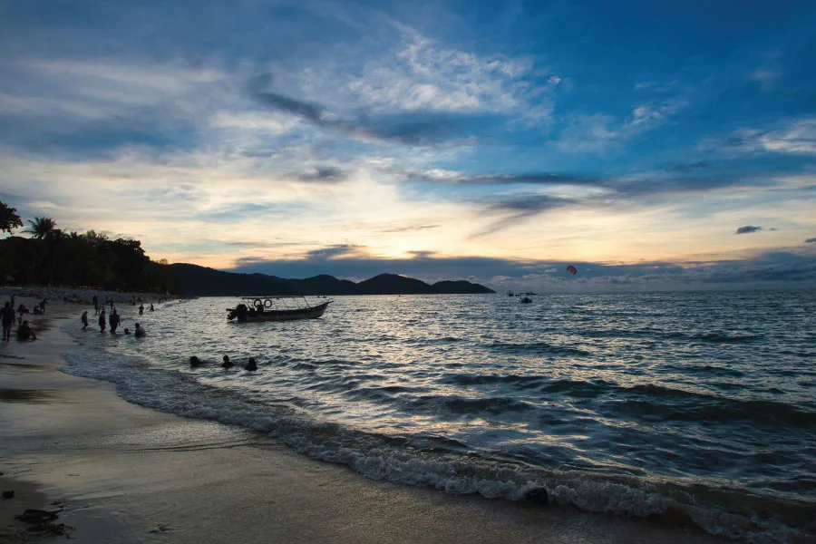 wooden boat floating on the sea with a sunset background