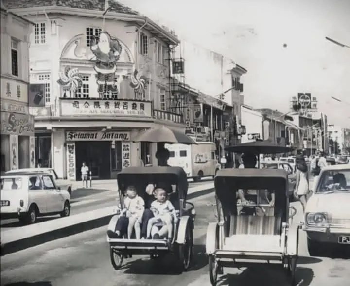 trishaws and motor vehicles on a street of an old city