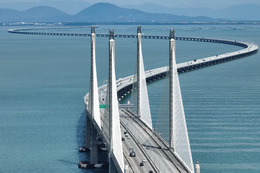 aerial view of a suspension bridge passing by the sea