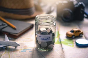 travel jar, hat, notebook, camera on a map