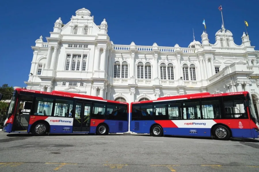 buses in front of a white building with heritage architecture