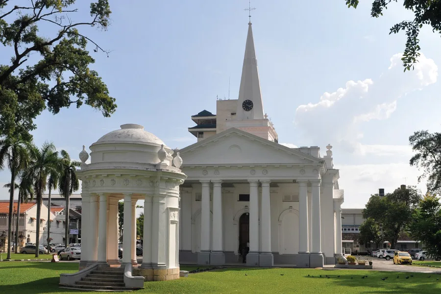 white church with heritage architecture with a green lawn