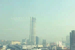 city skyline with a tall building and a hazy sky