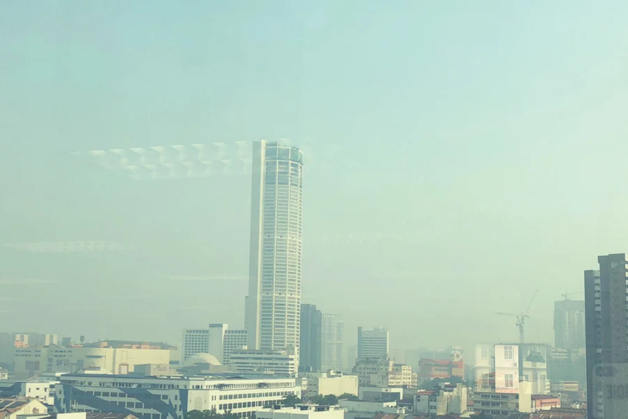 city skyline with a tall building and a hazy sky