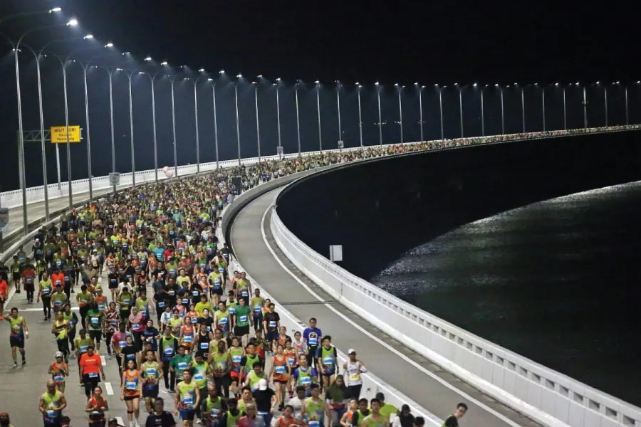 crowds running on a long bridge